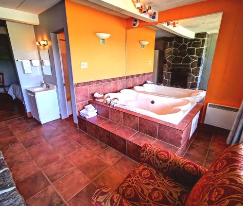 un ampio bagno con vasca e grande specchio di Motel Tremblant a Mont-Tremblant