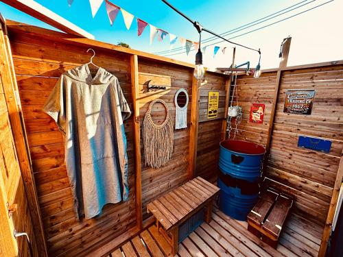 a wooden cabin with a shirt and a bench at アンカービレッジ九十九里 in Hasunuma