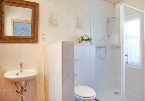 ein Badezimmer mit Dusche, Toilette und Waschbecken in der Unterkunft Bungalow "Wiesenblick" in Trassenheide