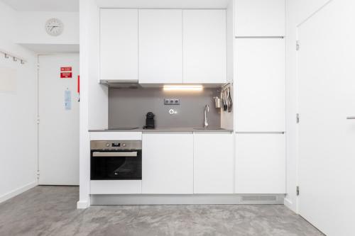 a kitchen with white cabinets and a sink at AveiNest - Your Studio in Aveiro in Aveiro