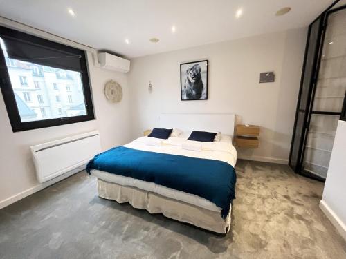 une chambre avec un lit et une grande fenêtre dans l'établissement 166 - Urban Luxury Apartment in Center of Paris, à Paris
