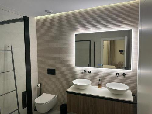 a bathroom with two sinks and a toilet and a mirror at Demetrio By Alma Suites in Valencia