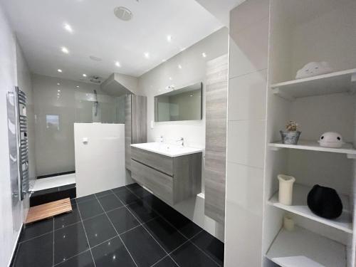 une salle de bain avec un lavabo et un réfrigérateur dans l'établissement 166 - Urban Luxury Apartment in Center of Paris, à Paris