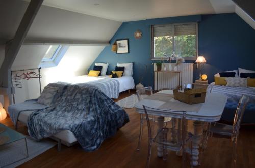 1 dormitorio con 2 camas, mesa y sillas en Le Copenhague en Lamorlaye