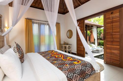 Postel nebo postele na pokoji v ubytování Ubud Raya Villa