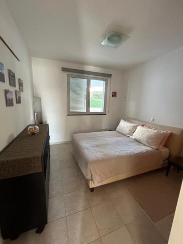 a bedroom with a large bed and a window at Vista Dourada in Porto Santo