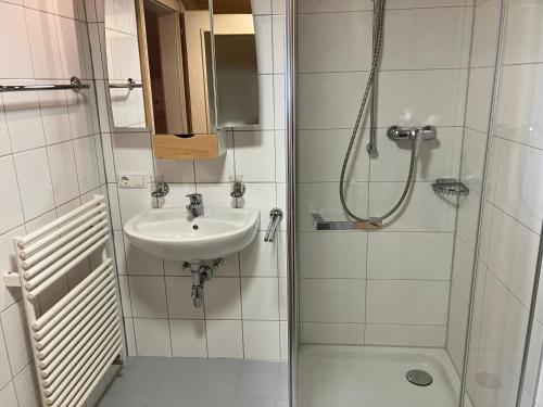 een kleine badkamer met een wastafel en een douche bij Ferienwohnung Bergblick am Rande der Wildnis in Sibratsgfäll