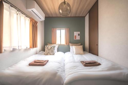 a room with two beds with towels on them at Japandi House Haneda in Tokyo