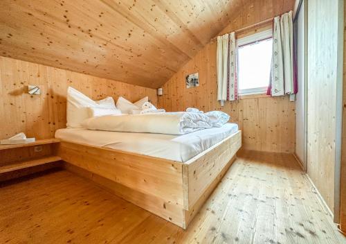 um quarto com uma cama num quarto de madeira em 1A Chalet Rast - Grillen mit Traumblick, Indoor Sauna em Bad Sankt Leonhard im Lavanttal