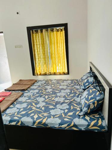 um quarto com uma cama e uma janela com cortinas amarelas em 3 BHK Holiday Home Near Airport em Nagpur
