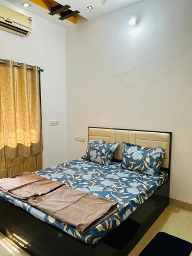 um quarto com uma cama com edredão e almofadas azuis em 3 BHK Holiday Home Near Airport em Nagpur