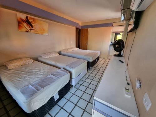 Habitación con 2 camas y TV. en Casa Aeroclube, en João Pessoa