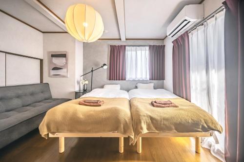 a bedroom with a bed and a couch at Japandi House Haneda in Tokyo