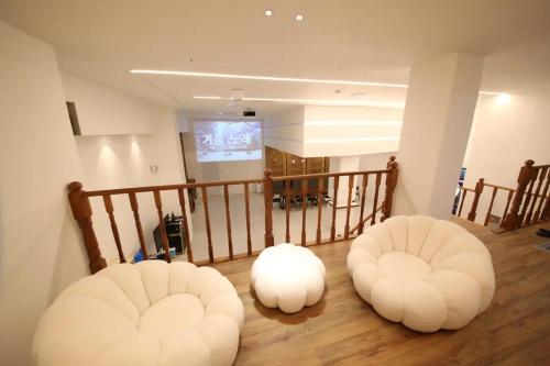 two white ottomans sitting on the floor in a room at Hotel141 in Daejeon
