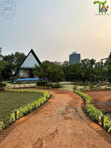 a brick road leading to a house with a glass at Luxurious 3BHK W//Pool Teakwood Villa By Gemstone Hospitality in Alibag