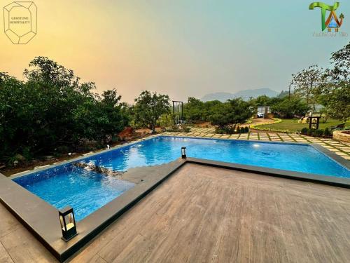 an image of a swimming pool at a resort at Luxurious 3BHK W//Pool Teakwood Villa By Gemstone Hospitality in Alibag