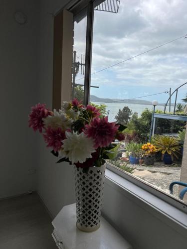 a vase filled with flowers sitting on a window sill at Water view retreat sanctuary in Koolewong