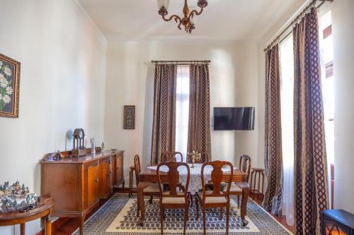 a dining room with a table and chairs at Era of Elegance: 1928 Classic Dwelling in Tripolis