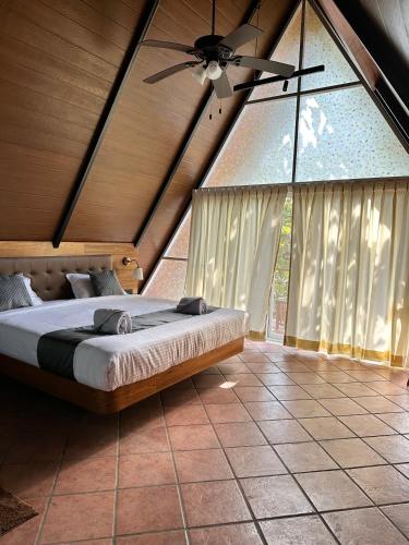 a bedroom with a bed and a ceiling fan at Luxurious 3BHK W//Pool Teakwood Villa By Gemstone Hospitality in Alibag