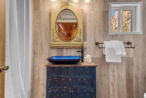 un bagno con un lavandino blu e uno specchio di Rock Face Lodge a Custer