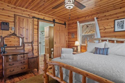 una camera con letto e cassettiera in una cabina di Rock Face Lodge a Custer