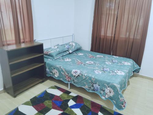 1 dormitorio con 1 cama con edredón azul en D Landai Budget Room Family, en Pekan