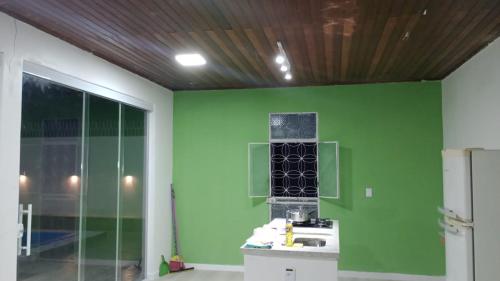 a room with a green wall and a sink at UM POUCO DE NATUREZA NO LAR in Manaus