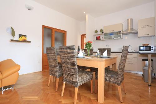 a kitchen and dining room with a table and chairs at Apartments Jadro in Vir