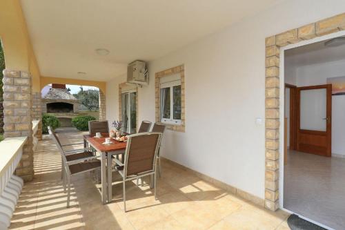 a dining room with a table and chairs on a patio at Apartments Jadro in Vir
