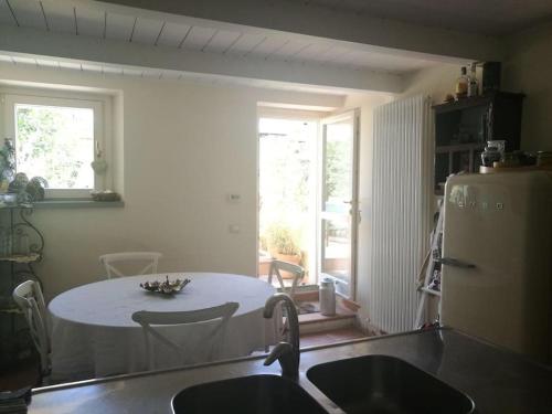 里米尼的住宿－Appartamento nel romantico Borgo San Giuliano，一间带桌子的厨房和一间带冰箱的厨房