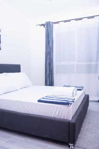 a bed in a room with a window at Semo's Siloam apartments in Mombasa