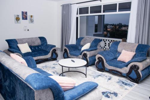 a living room with couches and chairs and a table at Semo's Siloam apartments in Mombasa