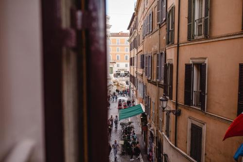 a group of people walking down a street between buildings at Delfini Trevi House in Rome