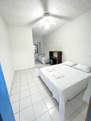 um quarto branco com uma cama grande em Pousada das Ostras em Anchieta
