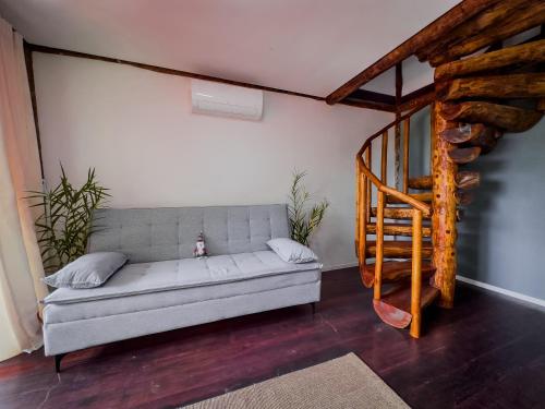 a living room with a couch and a staircase at Flats Apple Ilha com Banheira in Abraão