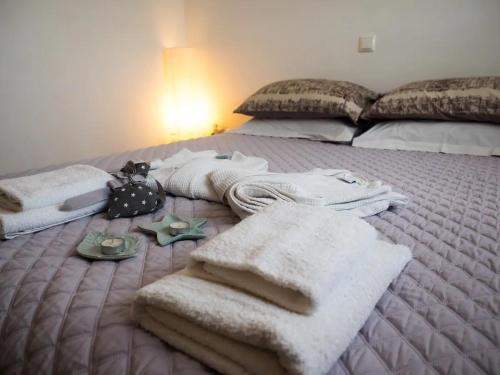 Una cama con mantas y toallas encima. en 7th Floor Stunning View Penthouse in Piraeus en Piraeus