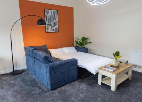 a bedroom with a bed and a blue chair at Stay at Waltz Gate in Horley