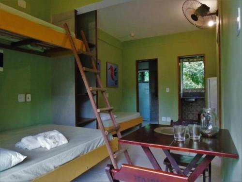 Zimmer mit einem Etagenbett, einem Schreibtisch und einer Leiter in der Unterkunft QUINTAL DA MATA in São Sebastião