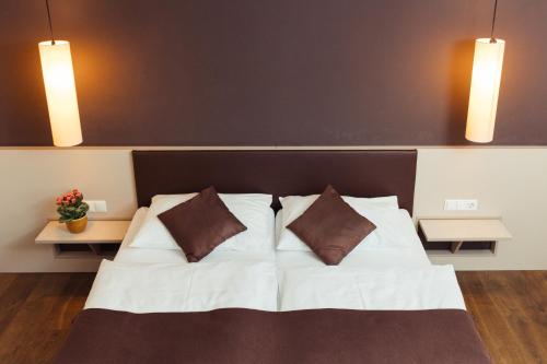 um quarto com uma cama branca e 2 almofadas em WEINBLICK & WEINGUT Grafinger em Senftenberg