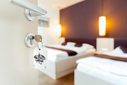una habitación de hotel con 2 camas y una etiqueta en una puerta en WEINBLICK & WEINGUT Grafinger, en Senftenberg