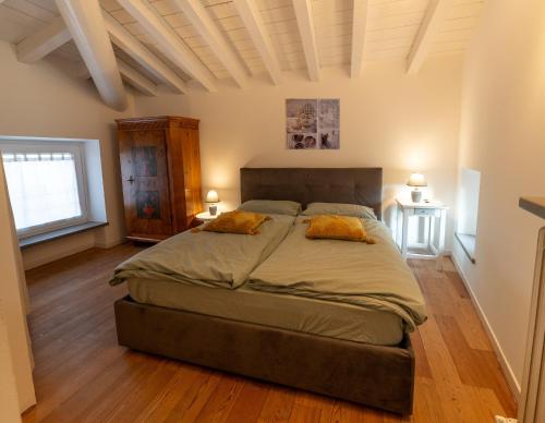 1 dormitorio con 1 cama grande y 2 almohadas amarillas en Ca Paradiso, en Caprino Veronese