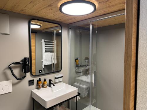 La salle de bains est pourvue d'un lavabo et d'une douche. dans l'établissement Hotel Restaurant Rössli, à Alt Sankt Johann