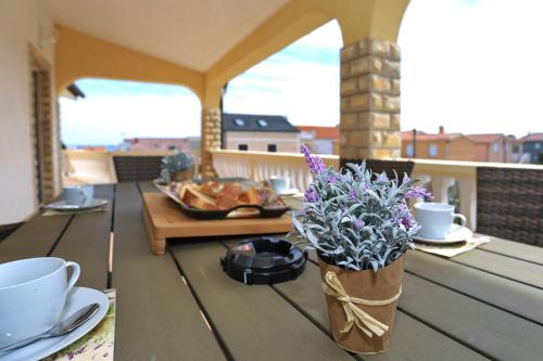 a wooden table with flowers on a balcony at Apartments Jadro in Vir