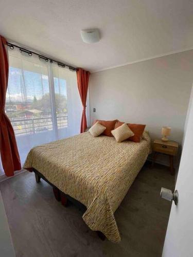 a bedroom with a bed and a large window at Depto. con Vista al Volcan in Villarrica