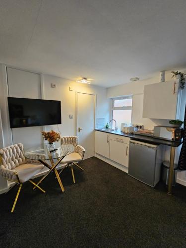 a kitchen with two chairs and a table in a room at Deluxe Town Centre Studio Stevenage in Stevenage