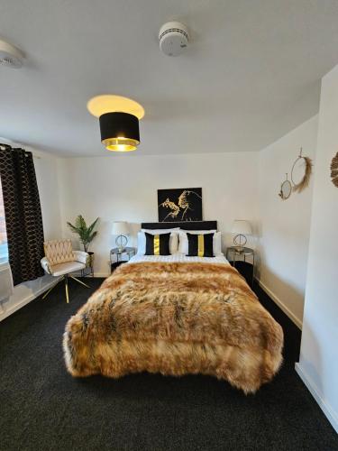a bedroom with a large bed with a large furhered bedspread at Deluxe Town Centre Studio Stevenage in Stevenage