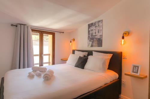 a bedroom with a bed with two towels on it at La Suite Neuvilloise in Neuville-sur-Saône