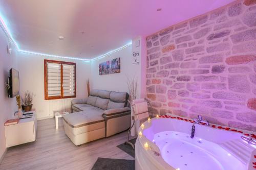 a living room with a bath tub and a couch at La Suite Neuvilloise in Neuville-sur-Saône