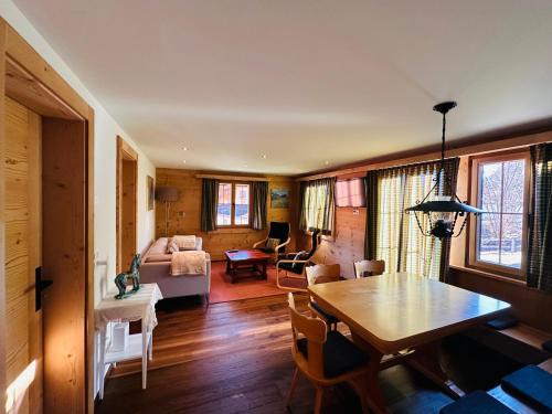 ein Wohnzimmer mit einem Tisch und einem Sofa in der Unterkunft Chalet Solaria 2 bedrooms with mountain and garden view in Zweisimmen