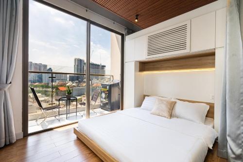 a bedroom with a white bed and a large window at Anthesis Riverside Apartment - Masteri Millennium in Ho Chi Minh City